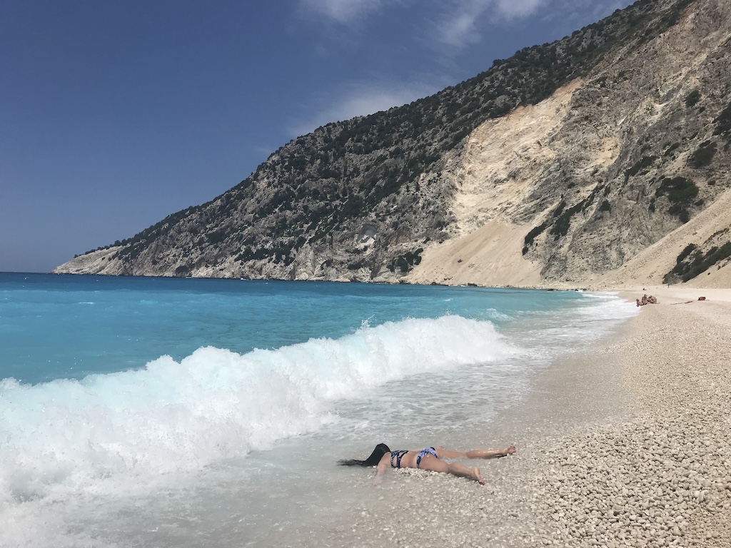 STEFDIES lying face-down on Myrtos Beach as a wave approaches